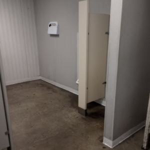 A bathroom featuring a toilet and sink, with neutral-colored walls and tiled flooring.